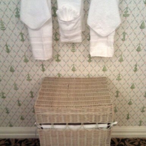 Towels and hamper across from sinks